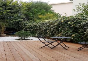 stół piknikowy i ławka na drewnianym tarasie w obiekcie Belle chambre au calme centre Montpellier w Montpellier