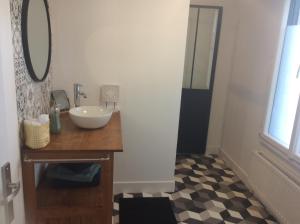 La salle de bains est pourvue d'un lavabo et d'un miroir. dans l'établissement Casa Cosy, à Lesneven
