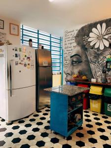 a kitchen with a refrigerator and a painting of a woman at Zili Pernambuco - Hostel Pousada in Recife