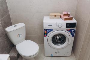 a bathroom with a toilet and a washing machine at Apart-hotel I. Sirko New Building 3 floor in Sumy