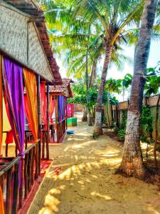 a row of houses with palm trees next to them at GoYm Resort in Arambol
