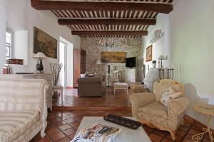 ein Wohnzimmer mit Sofa und Stühlen und einem Kamin in der Unterkunft La Marisol in LʼIsle-sur-la-Sorgue