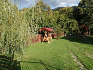 a garden with a swing set and a gazebo at Vila Carmen in Cazaci