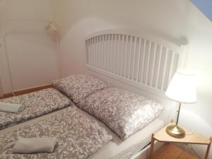 Dormitorio pequeño con cama y lámpara en Vienna Living Apartments - Rustengasse, en Viena