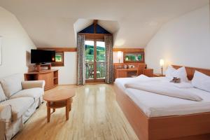 a bedroom with a large bed and a couch at Ayurveda Resort MANDIRA in Bad Waltersdorf +55 photos