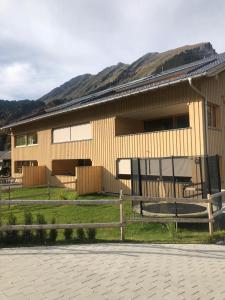 ein Haus mit einem Zaun davor in der Unterkunft Ferienwohnung Schnetzer Au in Au im Bregenzerwald