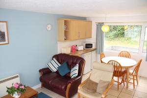 a kitchen with a couch and a table in a kitchen at Freshwater Bay Holiday Cottages in Pembroke