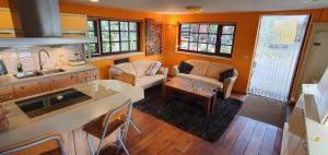 eine Küche und ein Wohnzimmer mit einem Sofa und einem Tisch in der Unterkunft Art, Bed & Breakfast in Velden