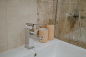 een wastafel in de badkamer met een kraan en een douche bij Bella's Sea apartment-Beach, Sea garden ,Old Town, Free Parking, Free EVcharging Station in Varna +33 foto's