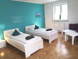 - 2 lits dans une chambre avec un mur bleu dans l'établissement Ferienwohnung zum Wohlfühlen, à Essen