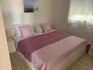 スベティ・フィリップ・イ・ヤコブにあるApartman Filipiのベッドルーム1室(ピンクと白の枕が備わるベッド1台付)