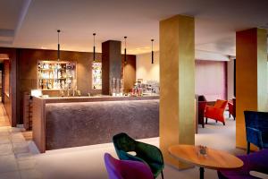 バート・ヴァルタースドルフにあるAyurveda Resort MANDIRAの紫色の椅子とテーブルが備わるバー付きのレストラン