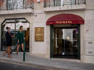two women walking down a street in front of a store at Madalena by The Beautique Hotels in Lisbon
