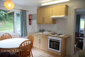 a kitchen with a table and a table and a dining room at Freshwater Bay Holiday Cottages in Pembroke