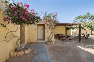 a building with a picnic table and flowers at SPNI Har Hanegev Field School in Mitzpe Ramon