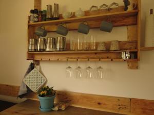 a bunch of wine glasses hanging on a wall at Mysthill Eco Cottage in Molen Drift