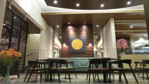 a restaurant with tables and chairs in a lobby at Sweet Garden Guest House in Malang