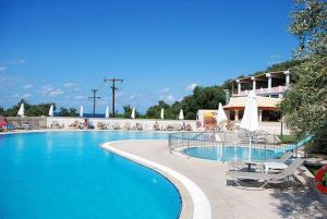 una gran piscina con sillas y un edificio en Aloha Hotel, en Agios Gordios