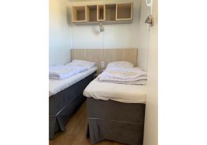 two twin beds in a small room with at Chaletparc Krabbenkreek Zeeland - Chalet 78 in Sint Annaland