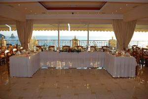 アギオス・ゴルディオスにあるAloha Hotelの白いテーブルと椅子が備わる宴会場