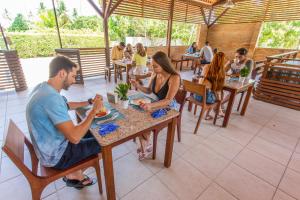 um grupo de pessoas sentadas numa mesa num restaurante em Pousada do Céu em Maceió
