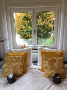 a bed with white sheets and pillows in front of two windows at Villa van Brienen - Studio in Dilsen-Stokkem