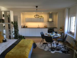 a bedroom with a bed and a table and a kitchen at Villa van Brienen - Studio in Dilsen-Stokkem