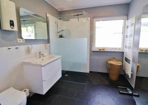 a bathroom with a sink and a toilet and a window at Fewo Haus Bellevue - inkl. MeineCard+ in Willingen +34 photos