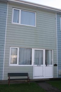 a house with a bench in front of it at Freshwater Bay Holiday Cottages in Pembroke