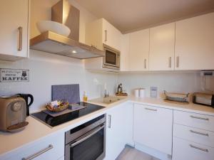a kitchen with white cabinets and a stove top oven at Fewo Haus Bellevue - inkl. MeineCard+ in Willingen