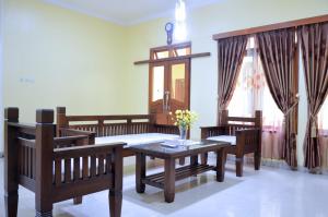a living room with wooden furniture and a table and chairs at Rumah Kuning Bandung in Bandung