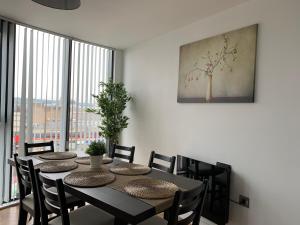 a dining room table with chairs and a large window at Lapwing - Sleeps up to 6, Fabulous panoramic city views, 12th Floor 2 bed city centre apartment, Perfect for work or leisure! in Sheffield