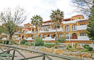 a large orange building with palm trees in front of it at Penthouse on the beachfront in Estepona
