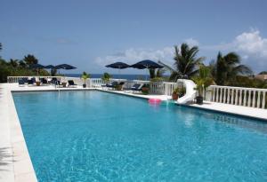 une grande piscine avec chaises et parasols dans l'établissement Princess Heights Luxury Condo Hotel, à Dawn Beach