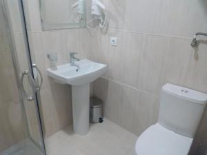 a bathroom with a sink and a toilet and a shower at Шик in Morshin