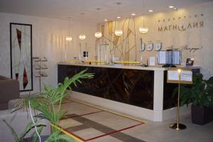 um lobby com um balcão com plantas e luzes em Отель Магнолия em Sochi