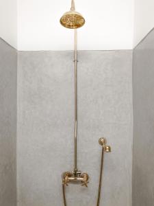y baño con ducha y luz en la pared. en Riad Dar-K, en Marrakech