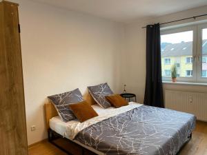 1 dormitorio con 1 cama con 2 almohadas y ventana en Moderne Wohnung bei Duisburg Hbf. en Duisburg