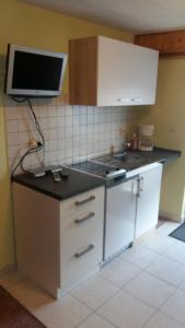 a kitchen with a stove and a tv on the wall at Haus am Sonnenhang in Wasungen