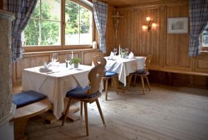 uma sala de jantar com duas mesas e cadeiras e uma janela em Hotel Rosskopf em Vipiteno