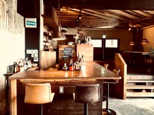 un bar con una gran mesa de madera y sillas en RoheN Resort&Lounge HAKONE, en Hakone