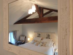 1 dormitorio con cama blanca y espejo en Chambres d'Hôtes Le Tilleul, en Saint-Hilaire-des-Loges