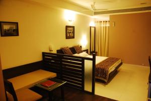 a bedroom with a bed and a couch and a table at Grand Ashirwad Beacon in Bhopal