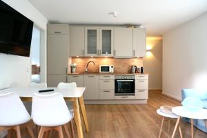a kitchen with white cabinets and a table and chairs at Strandglück in Scharbeutz