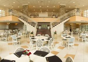 a restaurant with tables and chairs and a staircase at Il Campanario - Cobertura in Florianópolis