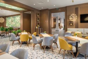 a restaurant with tables and chairs in a lobby at Hotel Jägerhof in Plovdiv