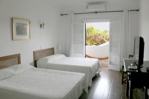Habitación de hotel con 2 camas y TV en Pousada Afrika, en Búzios