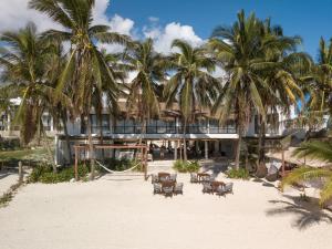 a resort on the beach with chairs and palm trees at Kinta Kan Beach Hotel Boutique Playa del Carmen in Playa del Carmen