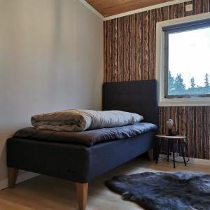 a bed sitting in a room with a window at Villa Björklund in Arjeplog