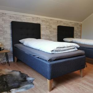 two beds in a bedroom with a dog laying on the floor at Villa Björklund in Arjeplog